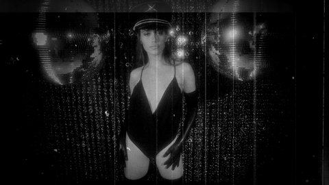 beautiful alluring woman in military hat and negligee dancing next to disco balls