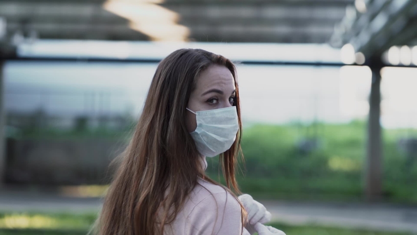 Young girl in medical mask and gloves shows stop sign