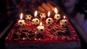 Lighting candles in the video of soccer balls on the cake.