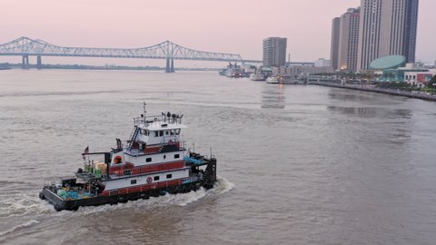Aerial:Tugboat on the Mississippi River and the city skyline at sunrise New Orleans, Louisiana, USA. 24 June 2019 