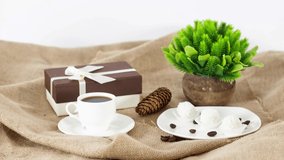 Coffee cup with gift boxes and flowers on wooden table background. *UHD
