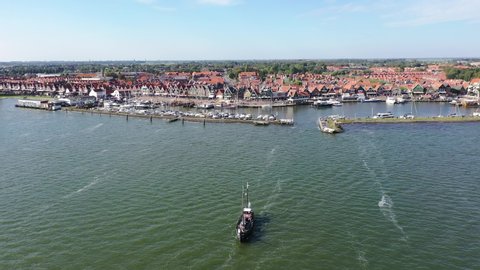4k Aerial drone view of the traditional dutch city / village Volendam. lots of tourist walking the streets. traditional buildings, bouts and harbor. The Netherlands in summer. Noord holland.