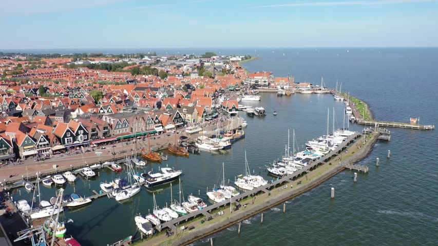 4k Aerial drone view of the traditional dutch city / village Volendam. lots of tourist walking the streets. traditional buildings, bouts and harbor. The Netherlands in summer. Noord holland. Royalty-Free Stock Footage #1049664304