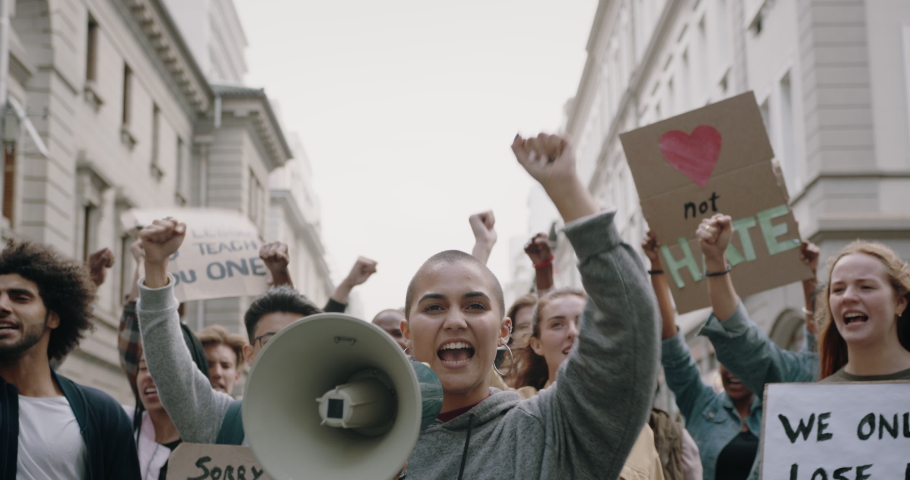 Group of demonstrators protesting during a march in the city. Social activists going on strike and demonstrating with slogans on the street.
 Royalty-Free Stock Footage #1049666167