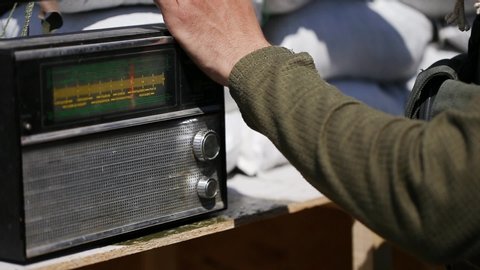 Transistor Retro radio. Person turned on the radio and began channel-surfing. Adjusts the sound