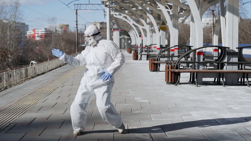 Dancing epidemiologist doctor after epidemic of coronavirus COVID-19 finished. Concept of global pandemic positive end. Funny virologist working in protective suit, glasses, gloves, mask.