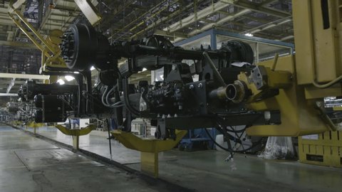 Production process of heavy mining trucks at the factory. Scene. Dump truck transmissionon the Industrial conveyor in the workshop of an automobile plant.