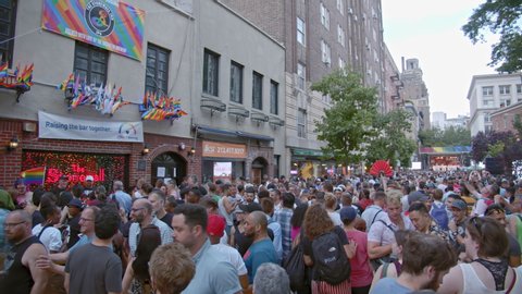 NEW YORK CITY, USA – JUNE 28, 2019: Crowd in front of The Stonewall Inn bar during the celebration of the 50th anniversary of the Stonewall riots, day time, slow motion
