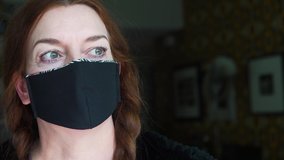 Portrait of an an experienced fashion designer wearing the face mask that she created at home  from recycled fabric as a protection against  viruses, disease and germs