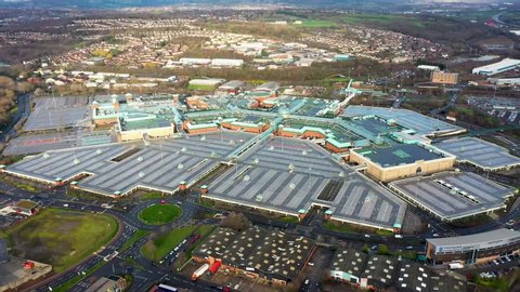Aerial footage of a large shopping centre known as Meadowhall, it's a indoor shopping centre in Sheffield, South Yorkshire, England showing the empty car park parking lot and glass roof