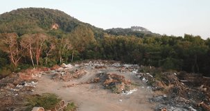 The image of a garbage dump is left in the forest, Near the water source and the sea, Aerial video from a drone