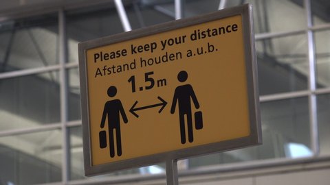 SCHIPHOL, THE NETHERLANDS – 1 APRIL 2020: Social distancing warning sign at Schiphol airport in the Netherlands, global coronavirus Covid-19 pandemic 
