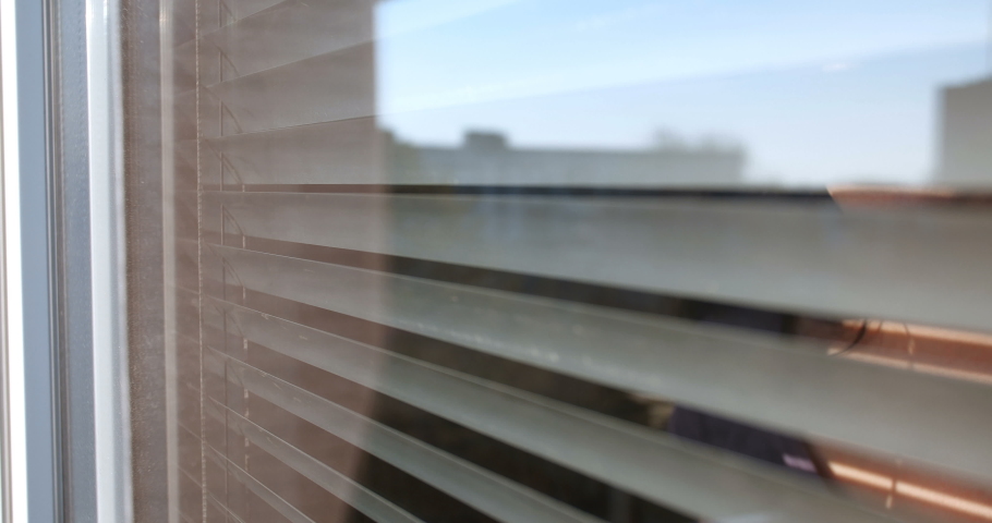 Close up front portrait from outdoors of attractive brunette woman pushing blinds at window with hands. Looking fearfully outside because afraid of germs. The concept of quarantine, self-isolation Royalty-Free Stock Footage #1049733925