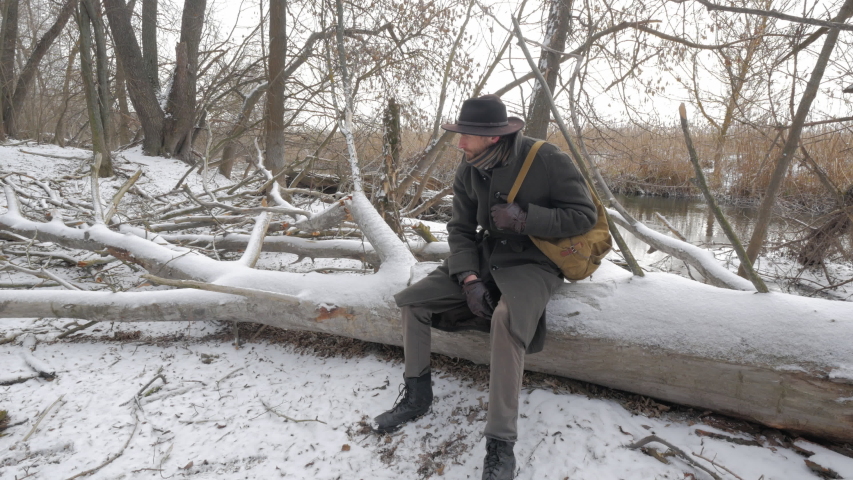 adult man siting in winter forest during his journey 