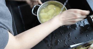 Peelings a potato skin in kitchen. Women's hands peel potatoes