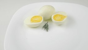 Two eggs. Healthy Breakfast. Cut in half. Rotating on a white plate. A sprig of dill. Boiled chicken egg. Bright yolk. Home cooking.Hard-boiled. - Powered by Shutterstock - Get 15% off with code: PIKWIZARD15