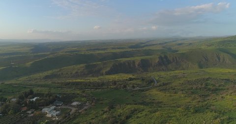 Aerial shot above Golan Heights and Taiberia in North of Israel. Open fields with green landscapes and mountains above Galilee sea or Kinnert at Jordan valley 