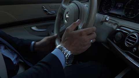 Kyiv, Ukraine, Oct 2018. Close-up Male Hands Turn Steering Wheel of Luxury Business Class Car. Mercedes-Benz S Class. Young Successful Businessman Confident Driving on Urban Highway, City Street