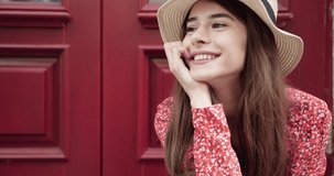 Close up portrait of a smiling cute girl with long hair and hat posing against white background