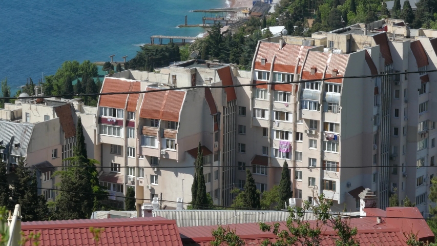 View on buildings with clotheslines near sea in summer day