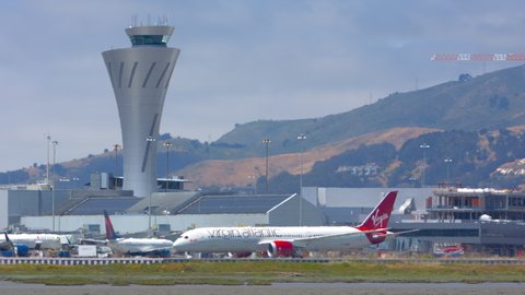 SAN FRANCISCO, CA - 2020: Virgin Atlantic Boeing 787-9 Dreamliner Jet Airliner Taxiing in Heat Waves Past SFO Air Traffic Control Tower and Terminal Building Exteriors in a Hot and Sunny California