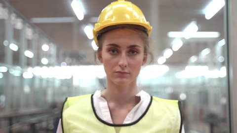 Labor woman worker is wearing protection mask face and safety helmet and wearing suit green reflective safety dress in high tech clean factory. Concept of smart industry worker operating.
