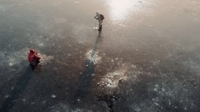Flying over a frozen river at dawn. winter fishing on thin ice. aerial video