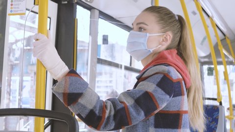 Pandemic COVID-19. A woman in a medical mask rides public transport bus. Prohibition of free movement. Social distance. Coronavirus quarantine in Europe.