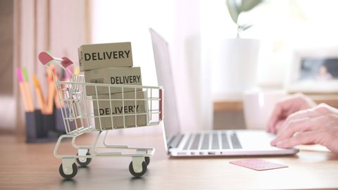 Delivered boxes fall in shopping cart right after placing online store order by customer