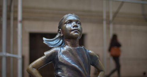 New York, New York / United States - March 23 2020: Fearless Girl Statue at the New York Stock Exchange. Tight profile of Fearless Girl looking at NYSE.
Camera pan from foot to head of statue.
