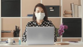 Work from home isolation coronavirus pandemic, Covid 19 quarantine. A young woman uses a medical mask and a hand sanitizer to protect himself. He works on a laptop. Stay self isolation at home - Powered by Shutterstock - Get 15% off with code: PIKWIZARD15