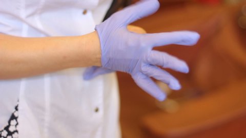 doctor puts on purple gloves