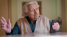 An authentic shot of a happy grandmother making a video call to relatives with a smartphone at home. Concept of technology, modern generation, family, connection, authenticity. - Powered by Shutterstock - Get 15% off with code: PIKWIZARD15