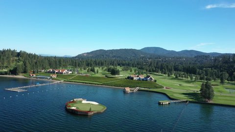 Panning aerial shot of the Coeur d'Alene Resort Golf Course on the lake with the world famous floating green.