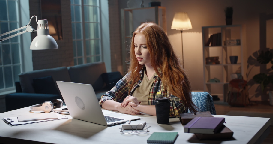 Positive caucasian girl looking at laptop webcamera during live internet stream, young influencer recording a vlog and expressively cheering 4k footage Royalty-Free Stock Footage #1049850685