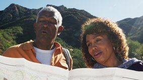 Senior couple looking at map as they hike along trail in countryside together - shot in slow motion - Powered by Shutterstock - Get 15% off with code: PIKWIZARD15