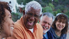 Group of senior friends on hike in countryside sitting on log talking and chatting together - shot in slow motion - Powered by Shutterstock - Get 15% off with code: PIKWIZARD15