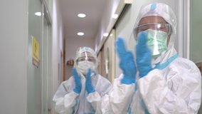 Two doctors in personal protective equipments clapping their hands to cerebrate the success of treatment. covid-19, coronavirus, medical, gratitude, healthcare concept - Powered by Shutterstock - Get 15% off with code: PIKWIZARD15