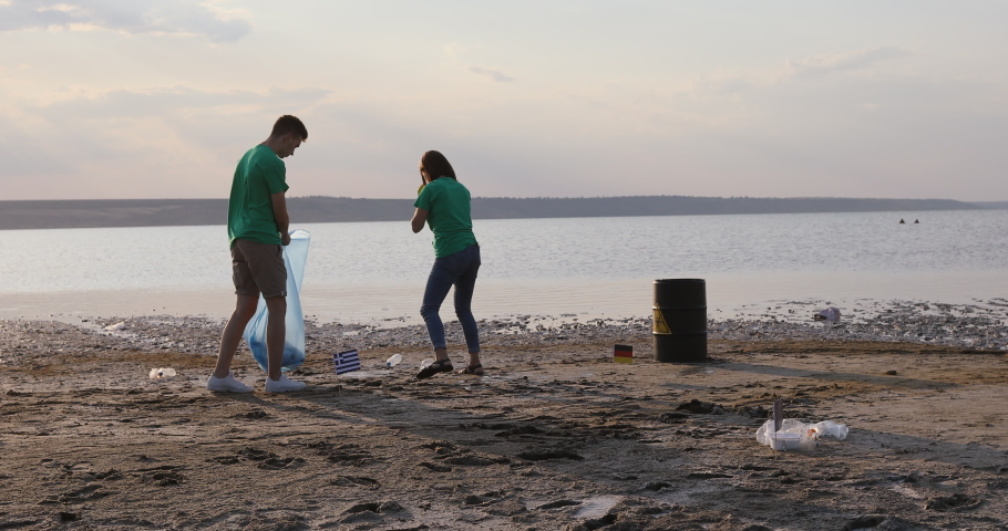 Volunteers collect garbage along the lake shore on a day off. Royalty-Free Stock Footage #1049887657