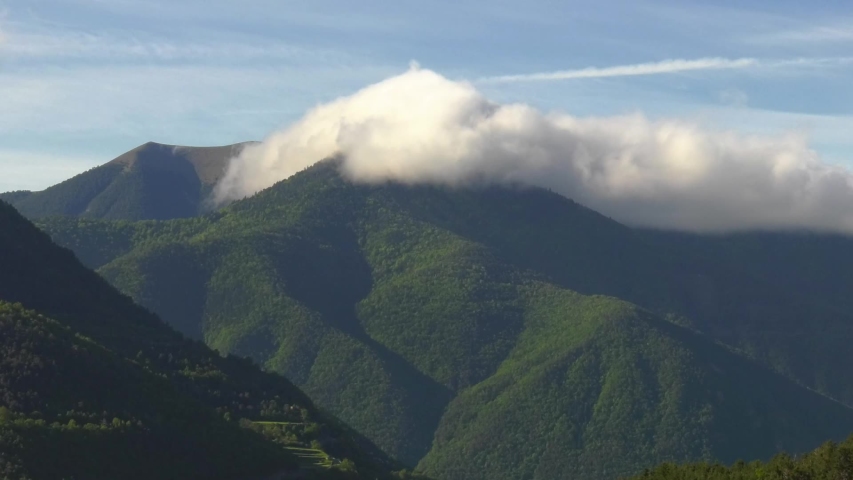 Clouds moving over forested mountains, spain