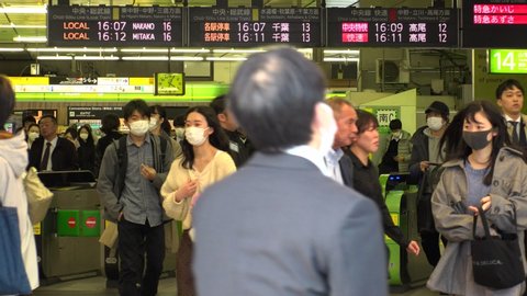 TOKYO, JAPAN - MARCH 2020 : Crowd of people at the street near Shinjuku station. Japanese people and foreign tourists wearing surgical mask to protect from Coronavirus (COVID-19) or cold or hay fever.