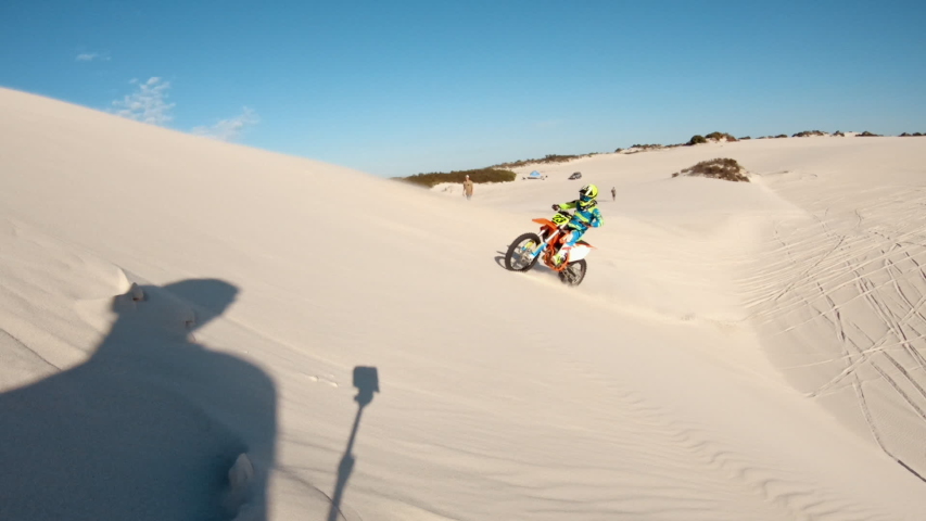 Skilled motocross rider drives on the sand dune. Dirt biker off roading on sand dunes in desert.
 | Shutterstock HD Video #1049895538
