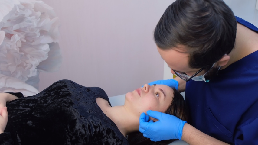 CLOSE UP: Young female patient having laser mole removal procedure done ...