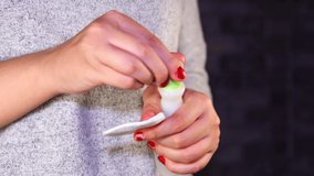 Woman removes red nail polish with nail polish remover. Lady removes the nail polish. Woman hand removing red nail polish with white cotton pad.
