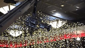 Video camera on crane filming live event indoor on a decorated studio with flashing lamps