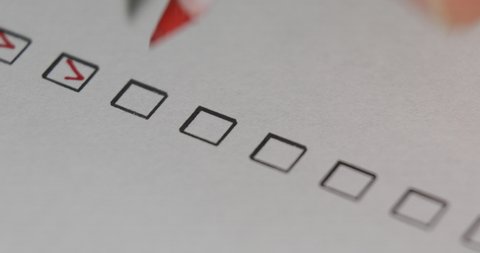 Person Ticks Checkbox Marks with a Pen, filling up To Do List. A person checking off a to do list with red pen. Check all the boxes of a checklist, close-up, 4k