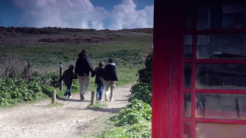 Family walking past red telephone box