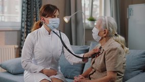 Female doctor use stethoscope to listen heart of elderly woman patient. Nurse home visit, checking health of old senior woman during coronavirus, covid-19 quarantine. - Powered by Shutterstock - Get 15% off with code: PIKWIZARD15