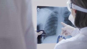 Doctors standing on white background examine x-ray for pneumonia of a Covid-19 patient in the clinic. Coronavirus concept - Powered by Shutterstock - Get 15% off with code: PIKWIZARD15