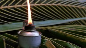 Traditional Malay oil lamps with coconut leaves background